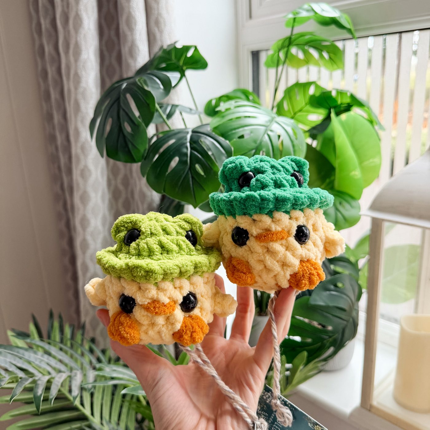 Crochet duck plushies wearing frog hats