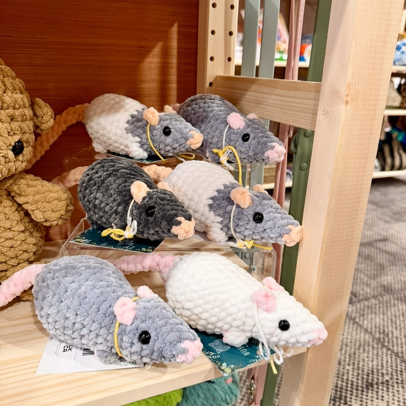 A shelf full of handmade crochet rat plushies